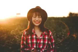 woman smiling with sun beams radiating behind her