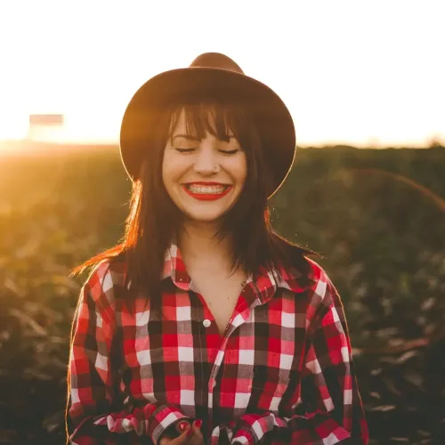 woman smiling with sun beams radiating behind her